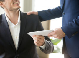 Employer handing an envelope to an employee